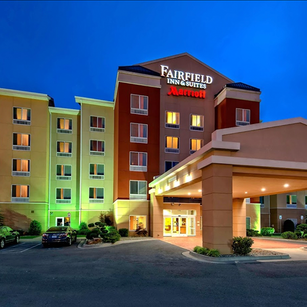 At dusk, the lights illuminate the entrance of a Fairfield Inn & Suites by Marriott hotel, where multiple windows gleam with clarity, offering a fresh perspective on the world—much like seeing anew after LASIK.
